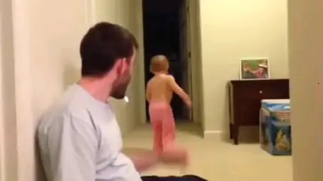 Man throwing a pillow at child