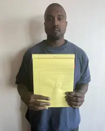 Kanye West holding a notebook