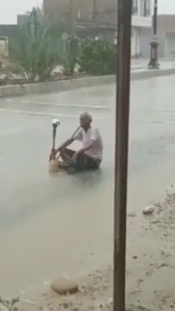 مرد در حال کشیدن  قلیون زیر باران