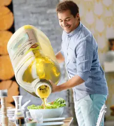 Man pouring olive oil on salad