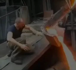 مرد درحال دست زدن به مواد مذاب