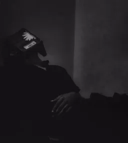 مرد تکیه داده به دیوار با کتاب روی صورتش