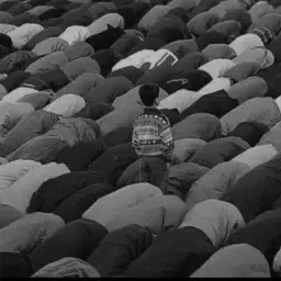 The boy standing in congregational prayer