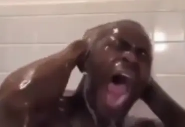 Black man crying the shower of bathroom