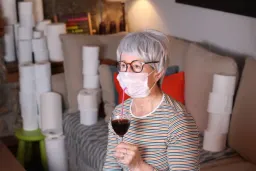 پیرزن درحال خوردن نوشیدنی با ماسک