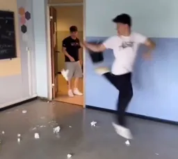 پسر در حال فوتبال بازی کردن با سطل آشغال در کلاس