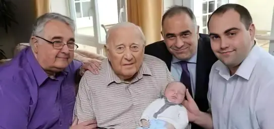 An old man next to his three generations