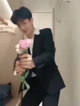 shy boy offering a flower