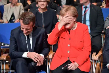 Macron Merkel laughing