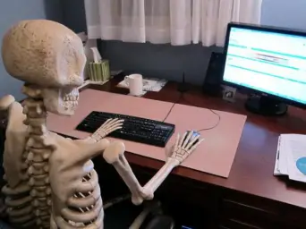 skeleton at computer desk